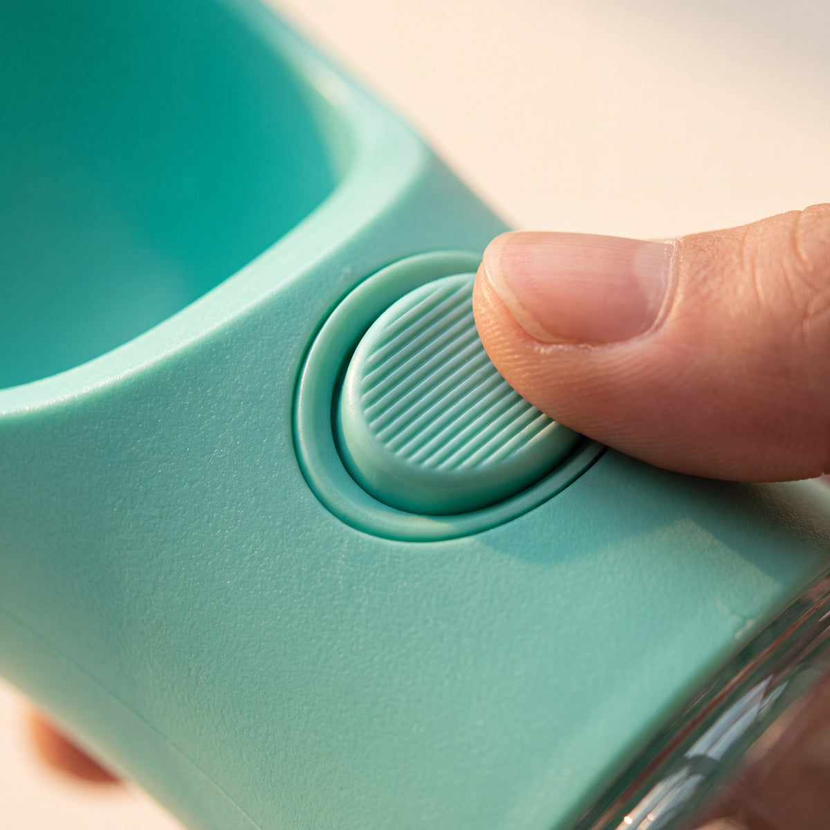 Close-up of the Trail Companion one-touch dispenser button being pressed with a thumb